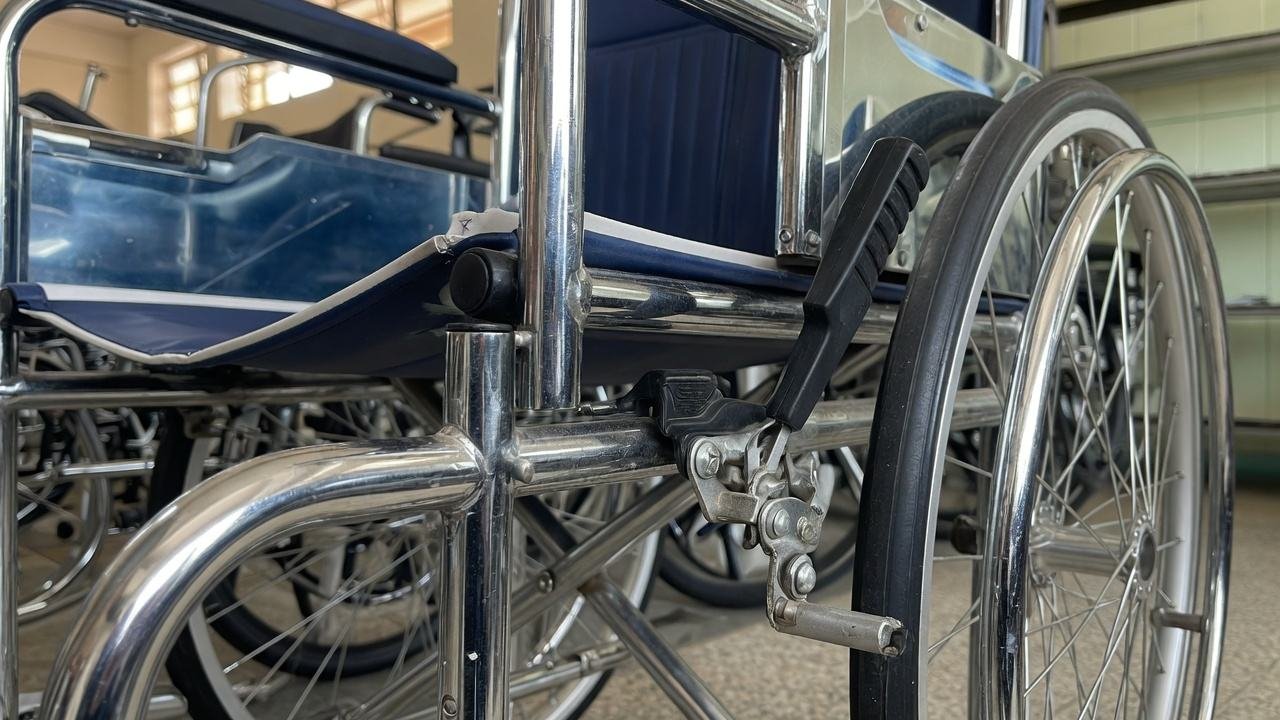 Push-to-lock wheelchair brakes on a chrome standard wheelchair in Nairobi